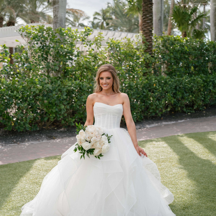 a girl wearing white gown & have bouquet