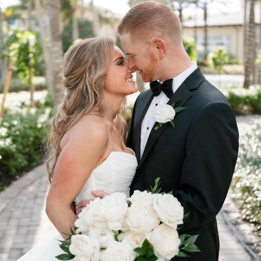 couple pose with white bouquet