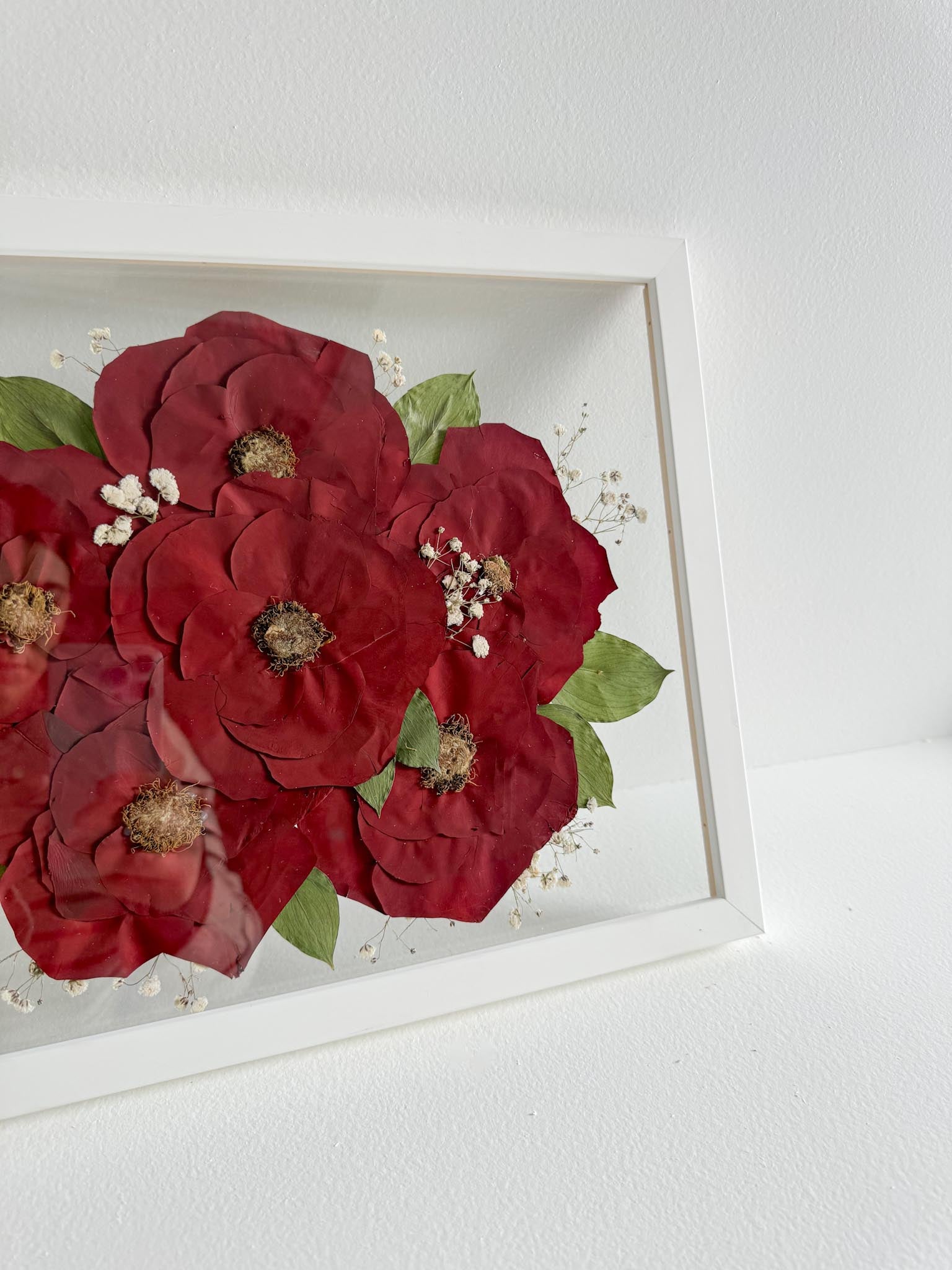 Framed artwork of red flowers