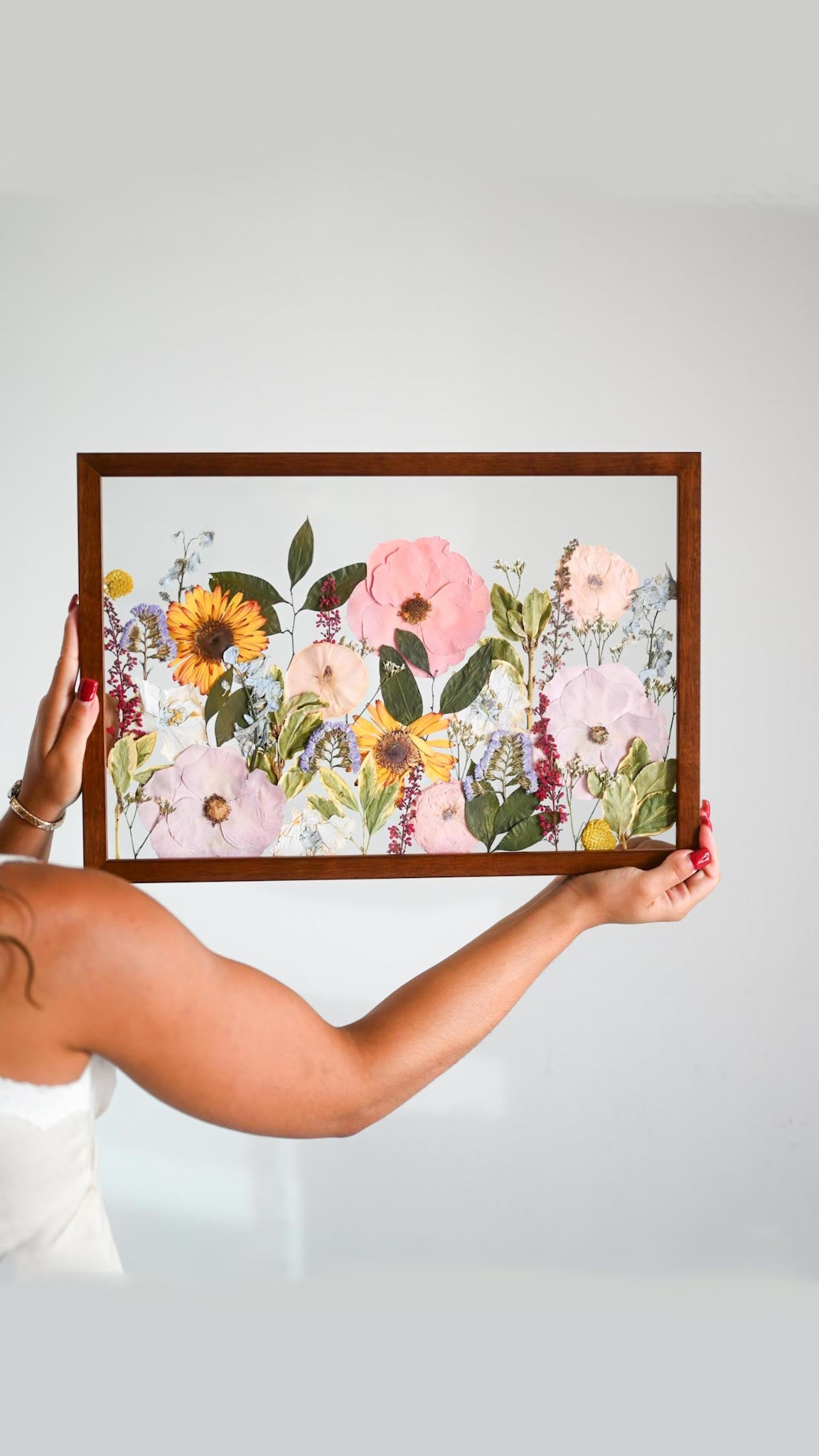 Person holding a framed floral print 