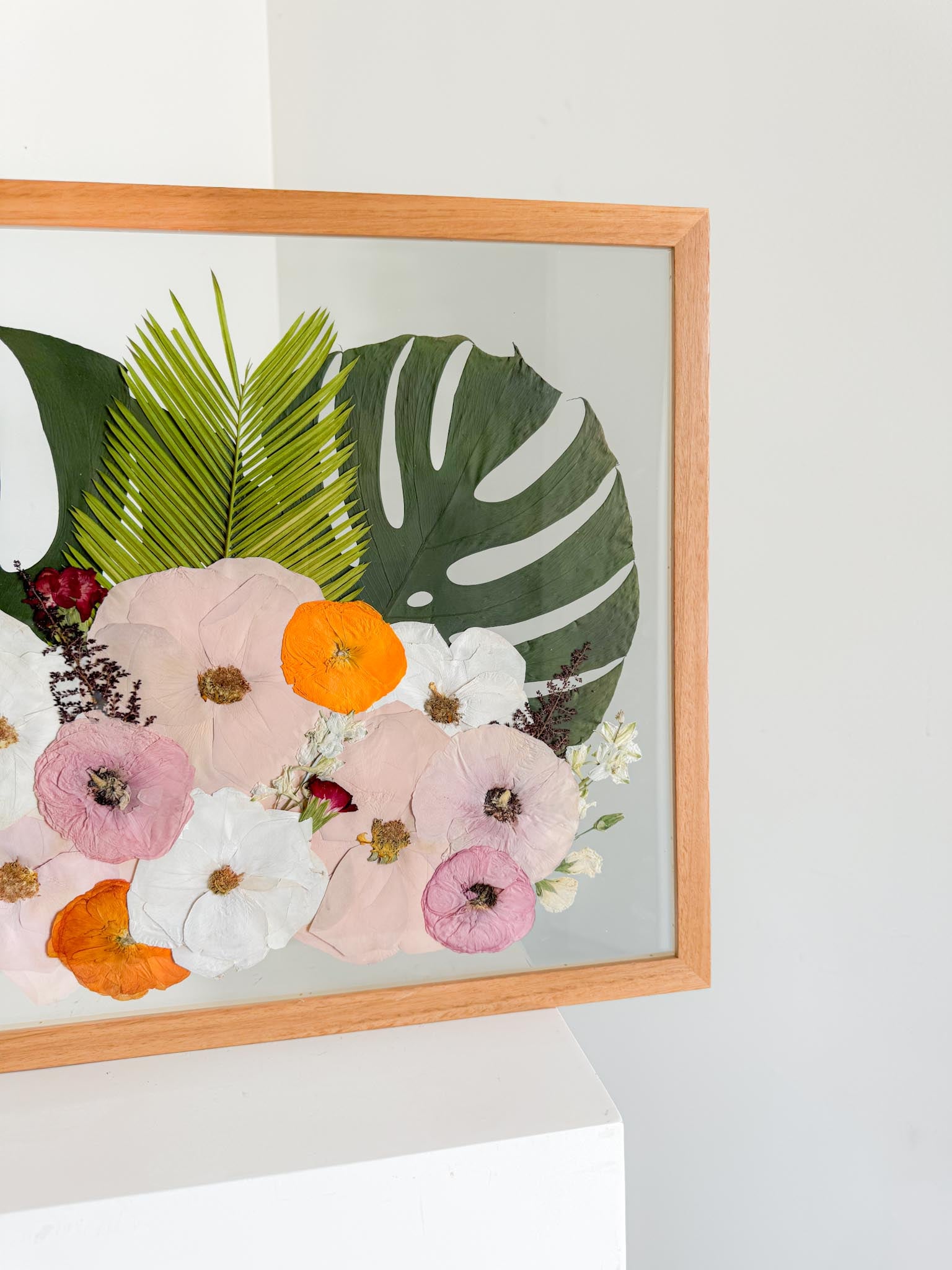 Framed artwork with pressed flowers and leaves 