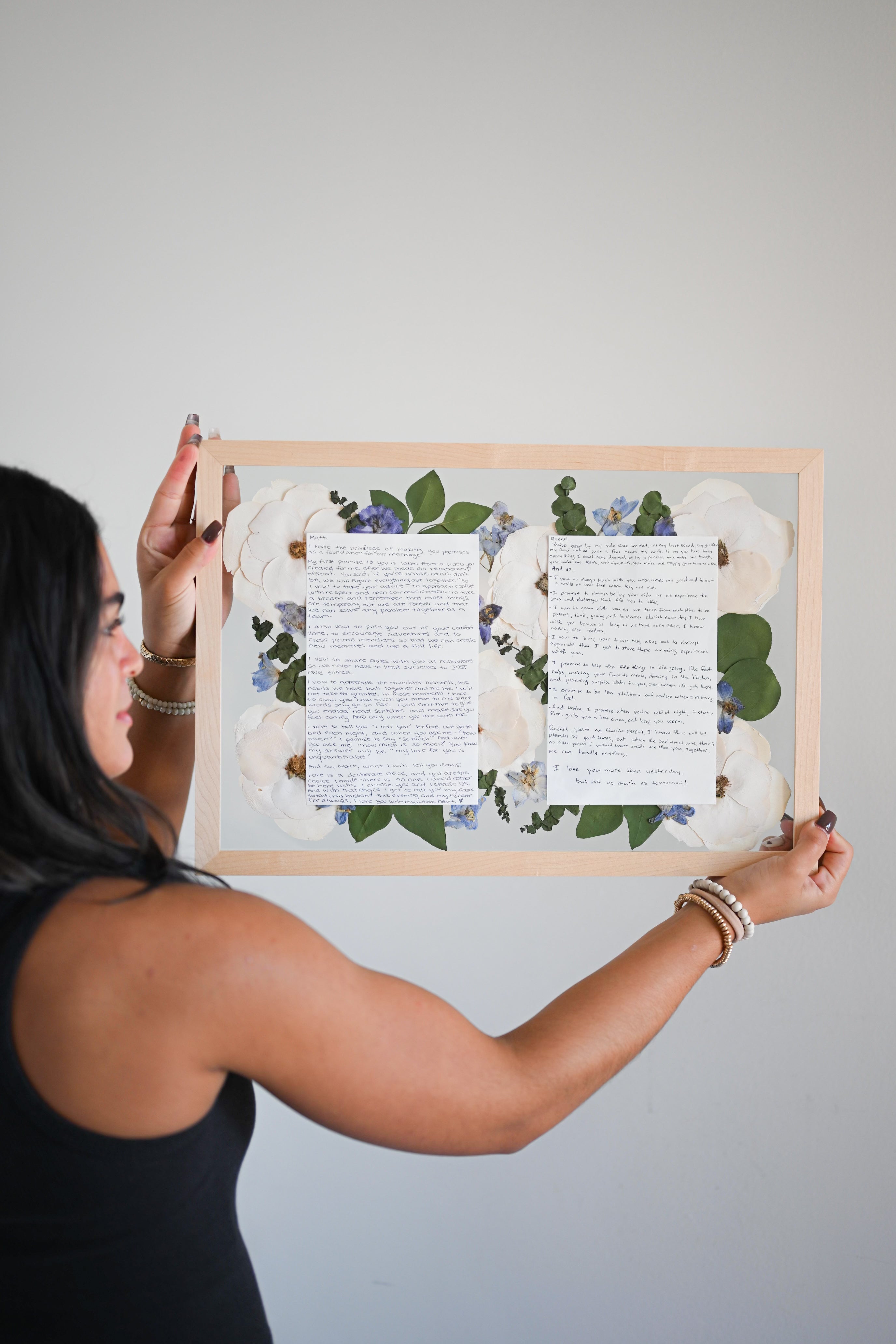 a frame that displays wedding vows surrounded by floral elements